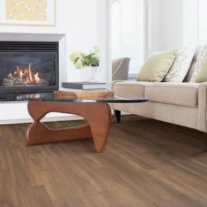 Laminate in a medium brown wood tone in a living room with a fireplace | Broadway Carpet & Flooring