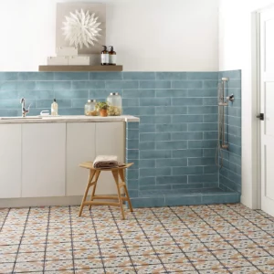 Mint blue subway tile on the wall and multi-colored patterned tile on the floor | Broadway Carpet & Flooring