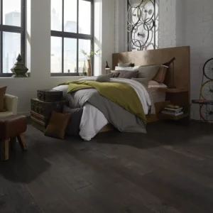 Dark hardwood in a modern bedroom with a large bed | Broadway Carpet & Flooring